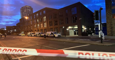 Relatives pray at police cordon after woman fatally stabbed in broad daylight