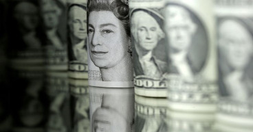Dollar gains, stocks slip as Fed officials talk tough on rates