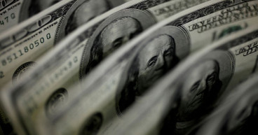 Dollar edges higher in range-bound holiday markets